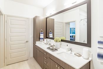 A bathroom with a sink, mirror, and towel rack.